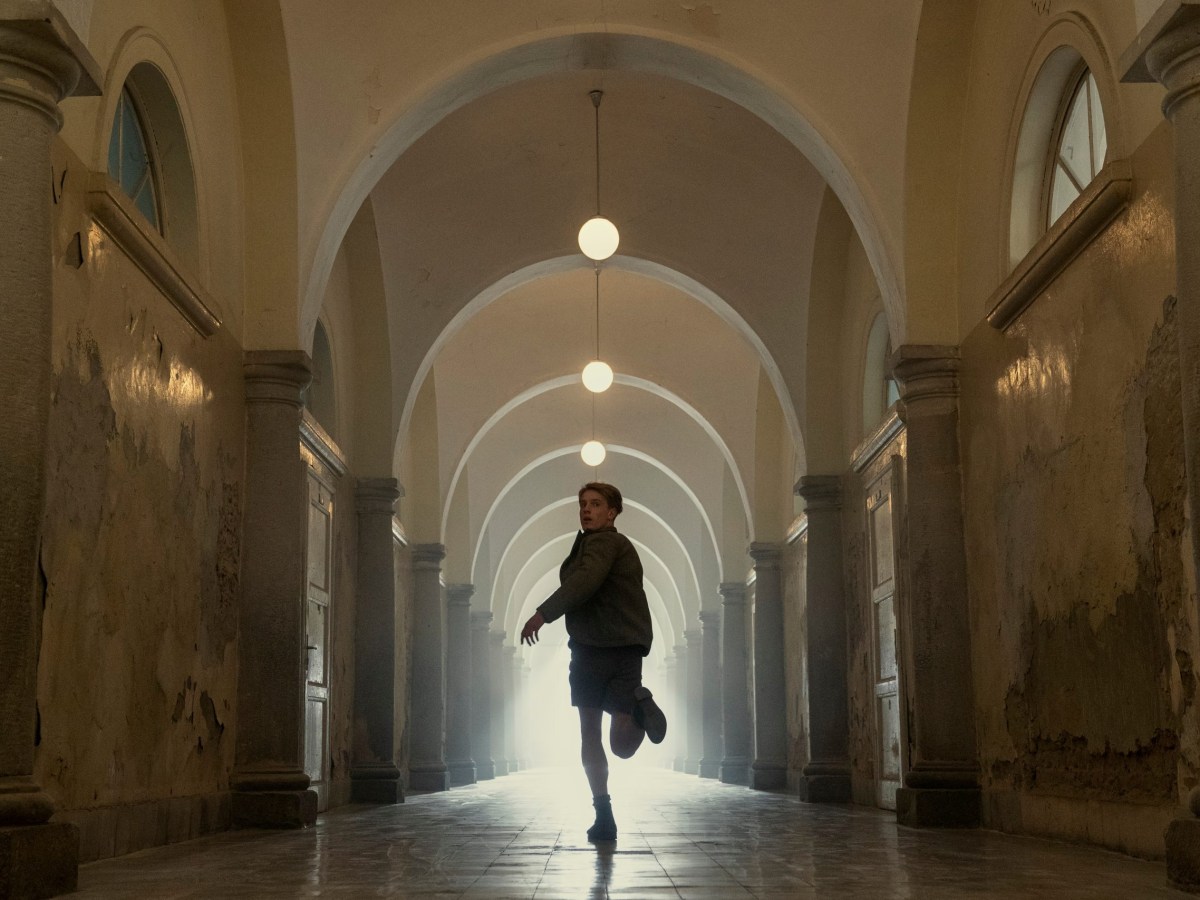 a person runs down a long, arched hallway