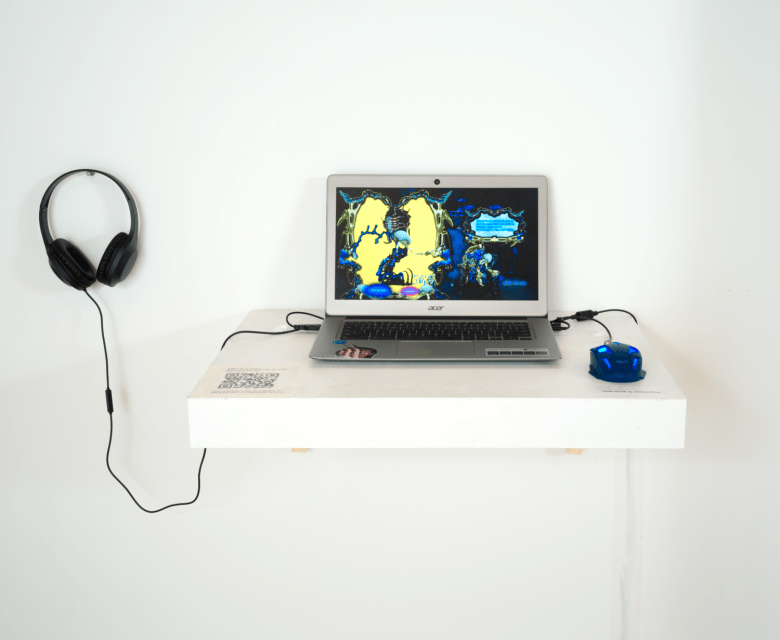 A laptop sits on a white shelf. A pair of headphones hangs on the wall nearby and a mouse connects to the computer. On the screen is a blue and yellow animation.