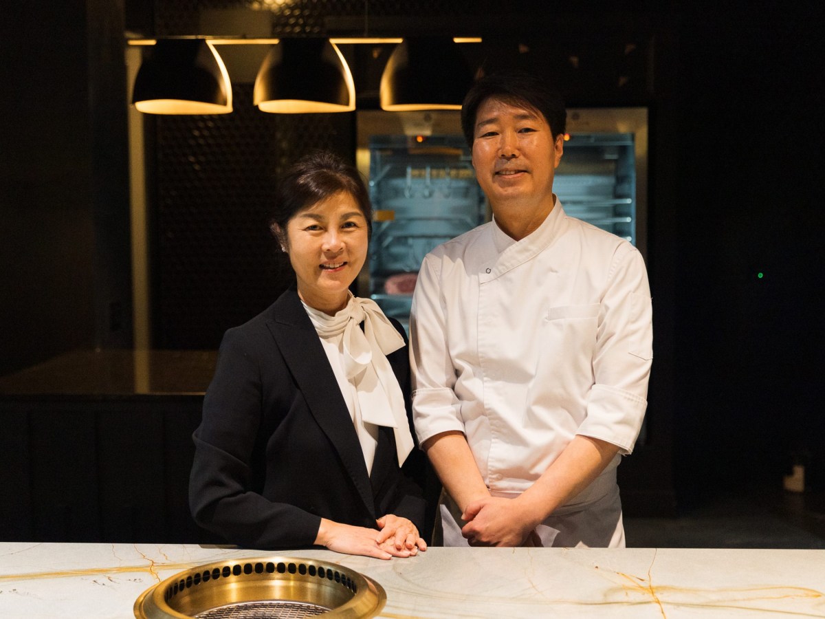 an Asian couple stands at a counter