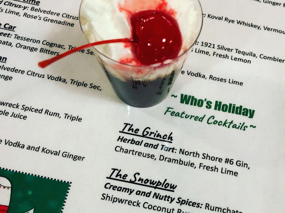 Green dessert shot with whipped cream and cherry on top of Theater Wit bar menu