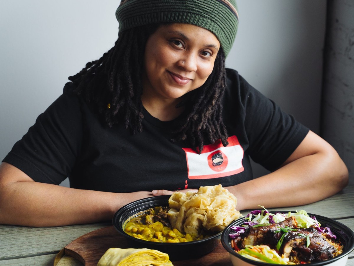 Dawn Lewis of D's Roti & Trini Cuisine with delicious dishes of “buss up shut,” Chinese chicken, doubles, and dhalpuri
