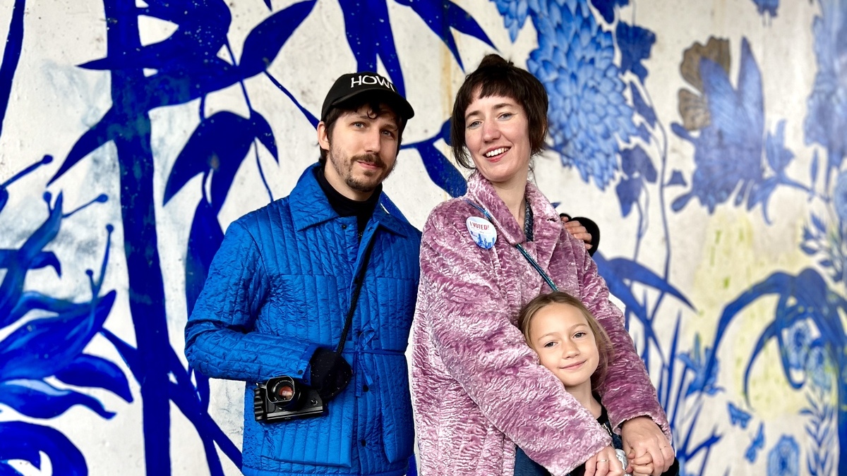 Gábor Hizó, Alanna Zaritz, and their daughter Zel standing in front of a mural in Pilsen, Chicago