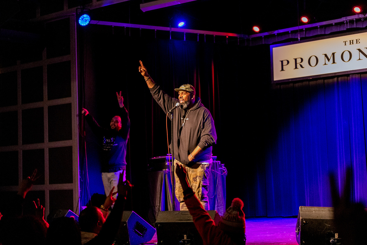 grown folks stories host binkey at the microphone on stage at the promontory club in chicago with a DJ in the background