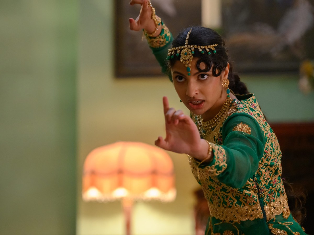 a young Indian woman in green and gold poses ready for a fight
