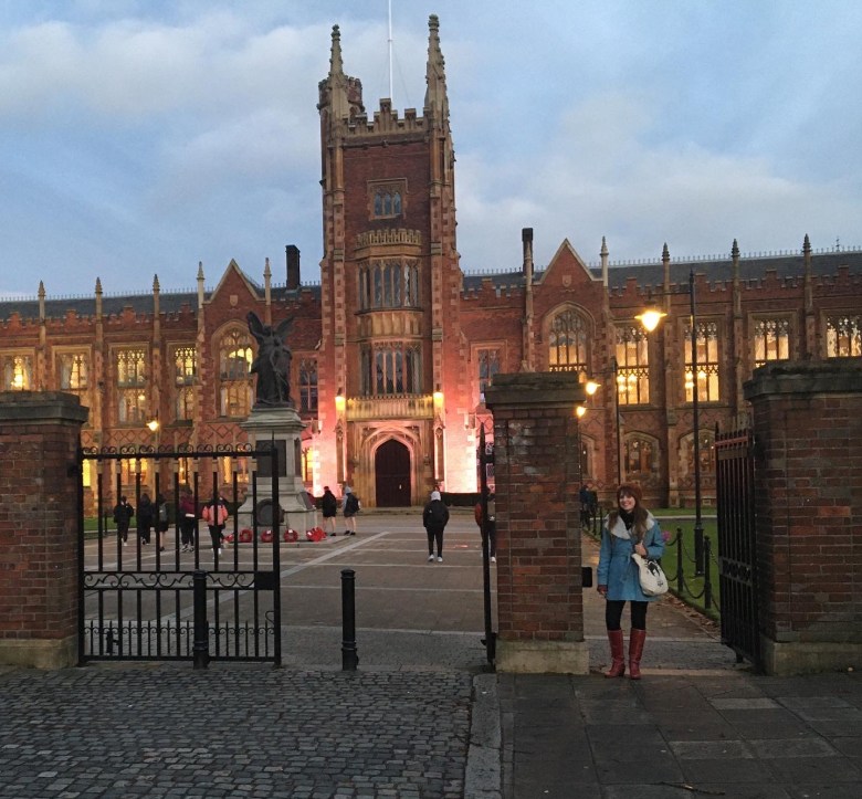 a regal brick university building of obvious advanced age, with a tower decorated with spires over the main gate