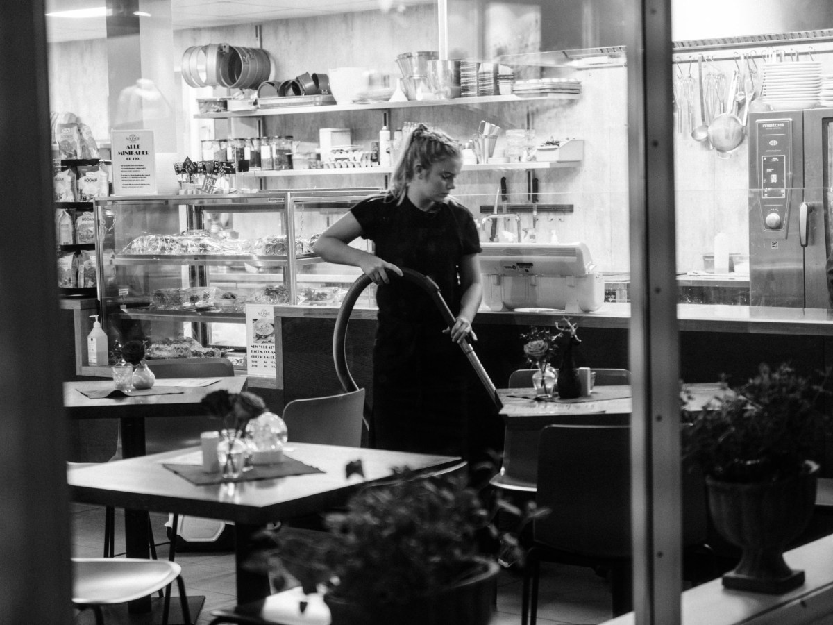 A worker cleans an empty restaurant