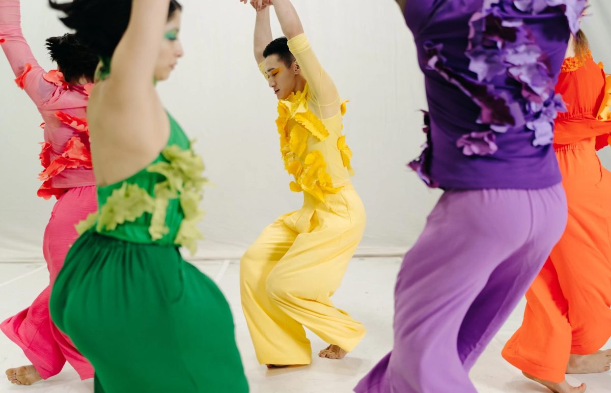 Five dancers in Superbloom perform. They are each wearing a different brightly colored costume with flowery leaves attached to the tops.
