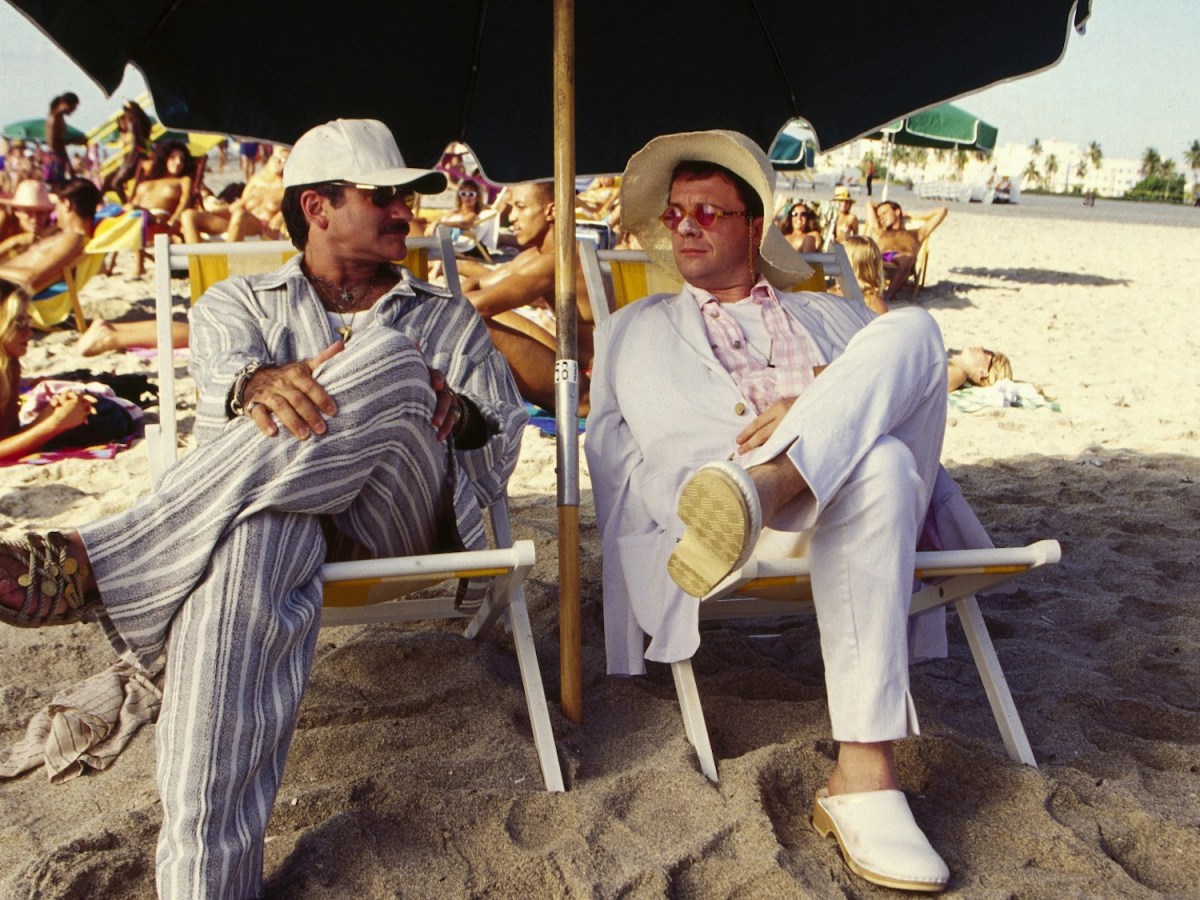 two men sit in beach chairs